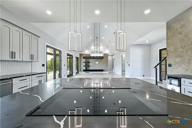 a kitchen with stainless steel appliances granite countertop a sink counter space cabinets and a large window