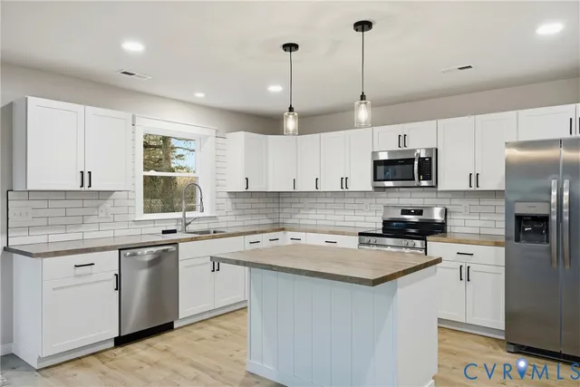 a kitchen with a sink a counter space appliances and cabinets