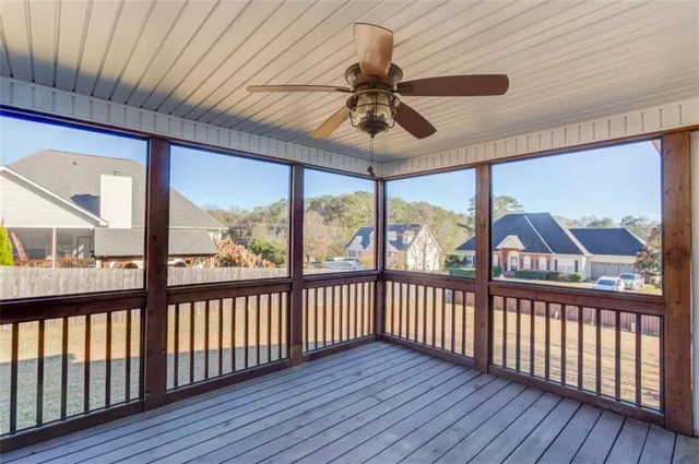 a view of a room with wooden floor fan and windows