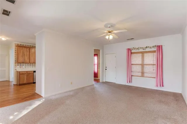 en empty room with windows and fan