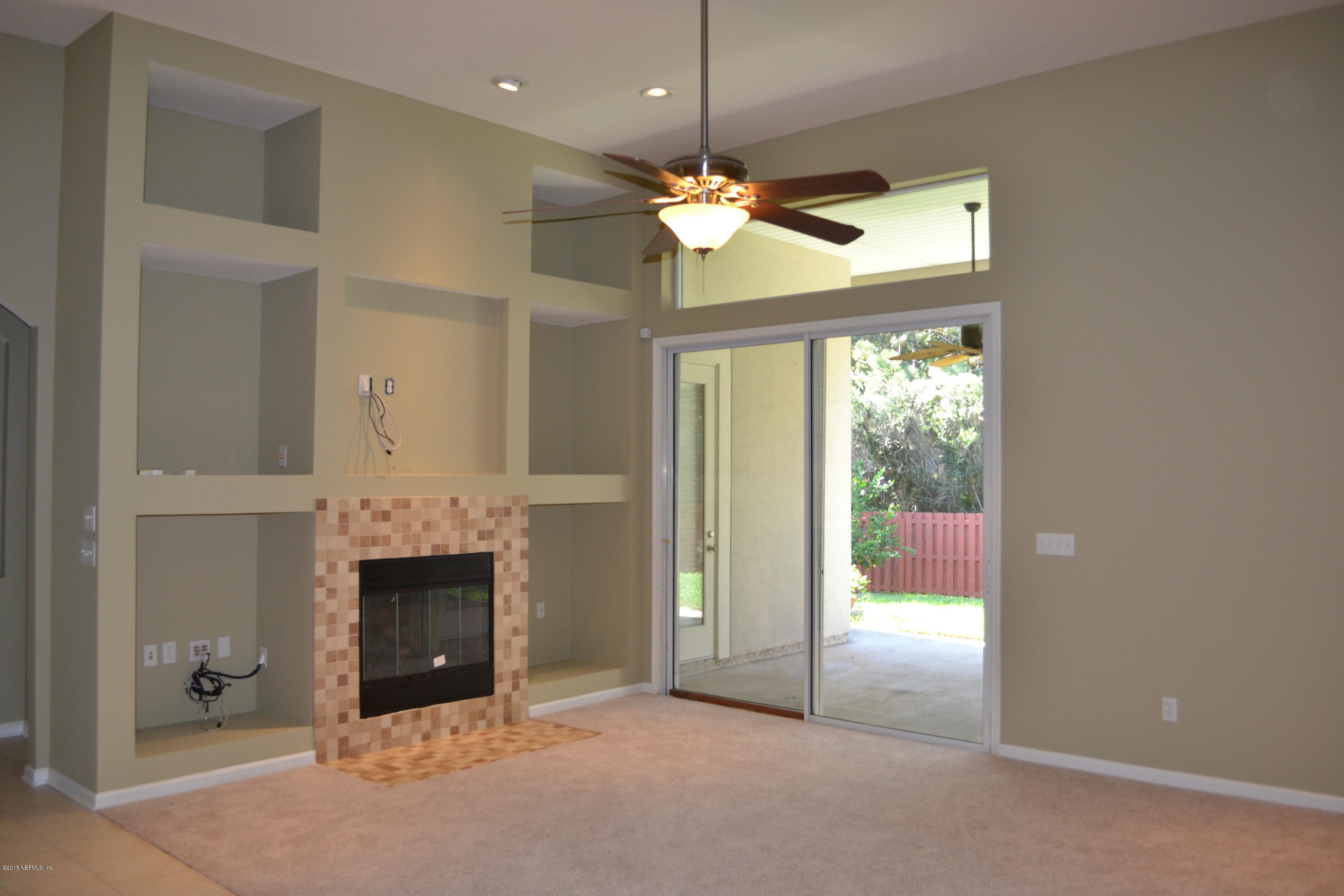 14422 Millhopper Road Jacksonville, FL 32258 - Photo 13 of 65 a view of an empty room with a fireplace and a window