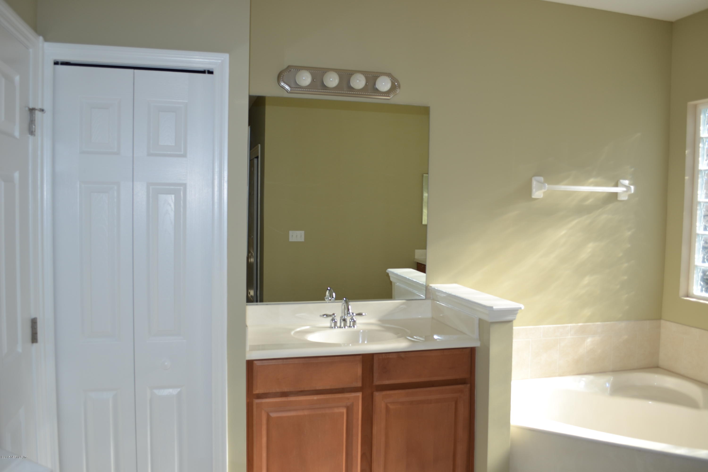 14422 Millhopper Road Jacksonville, FL 32258 - Photo 20 of 65 a bathroom with a sink and a mirror