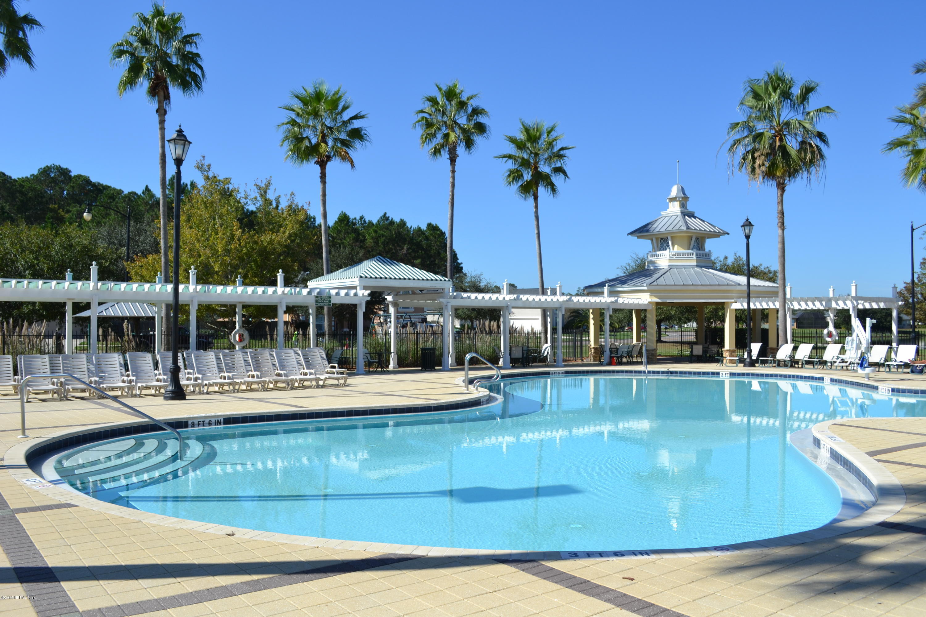 14422 Millhopper Road Jacksonville, FL 32258 - Photo 62 of 65 a view of a swimming pool with a table and chairs under an umbrella
