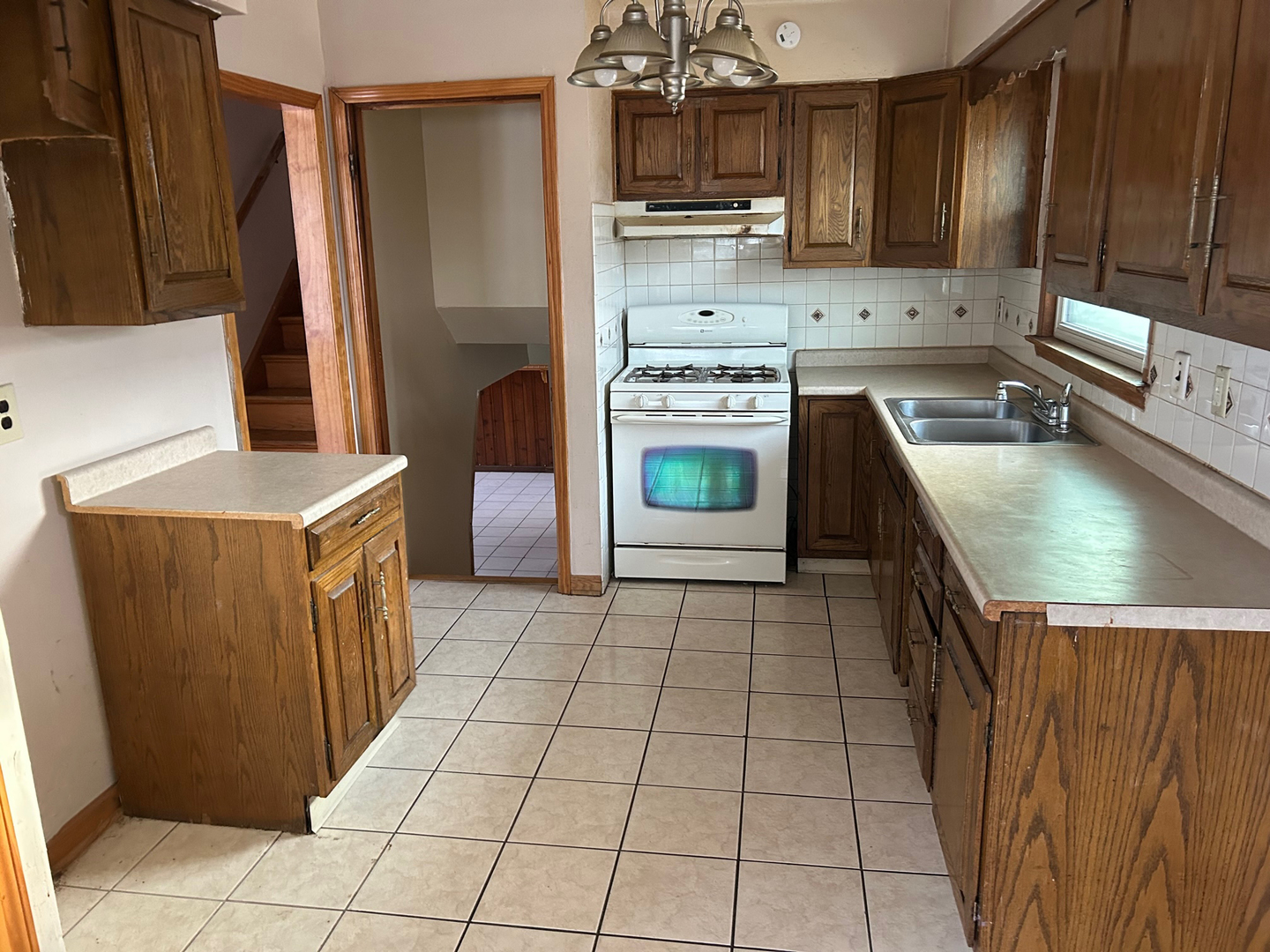 12919 South Escanaba Avenue Chicago, IL 60633 - Photo 9 of 16 a kitchen with kitchen island granite countertop a stove a sink a refrigerator and a microwave