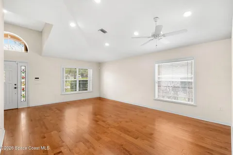 a living room with a flat screen tv and kitchen view