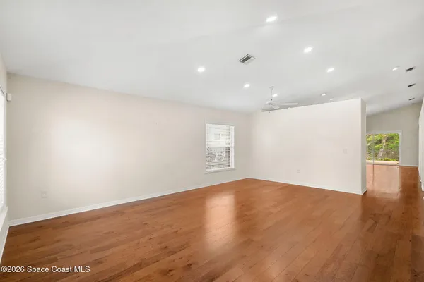 a living room with a flat screen tv and kitchen view