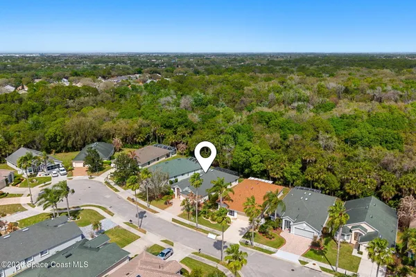a view of a kitchen with kitchen island a sink wooden floor and a refrigerator