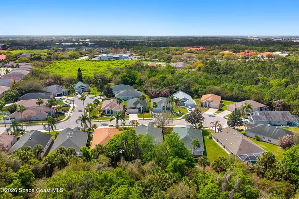 a view of an empty room with wooden floor and a ceiling fan
