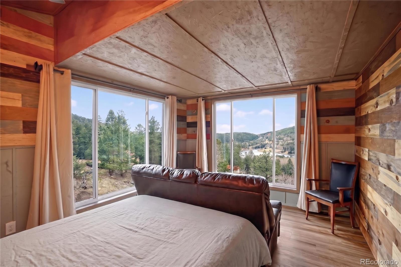 161 Highland Circle Rye, CO 81069 - Photo 18 of 26 a bedroom with a bed and a large window with balcony view