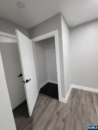 an entryway space with wooden floor and staircase