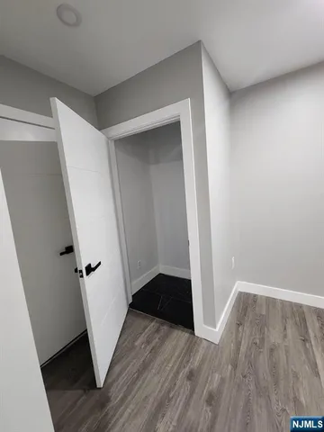 an entryway space with wooden floor and staircase