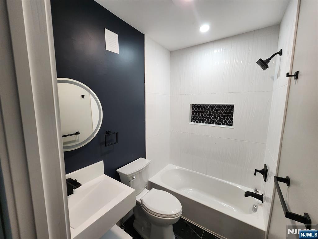93 Hughes Street, Unit 2 Maplewood, NJ 07040 - Photo 13 of 16 a bathroom with a toilet a sink and bathtub