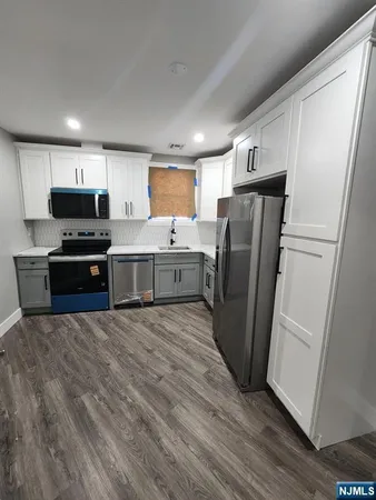 a kitchen with stainless steel appliances a refrigerator sink and microwave