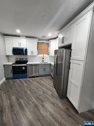 a kitchen with stainless steel appliances a refrigerator sink and microwave