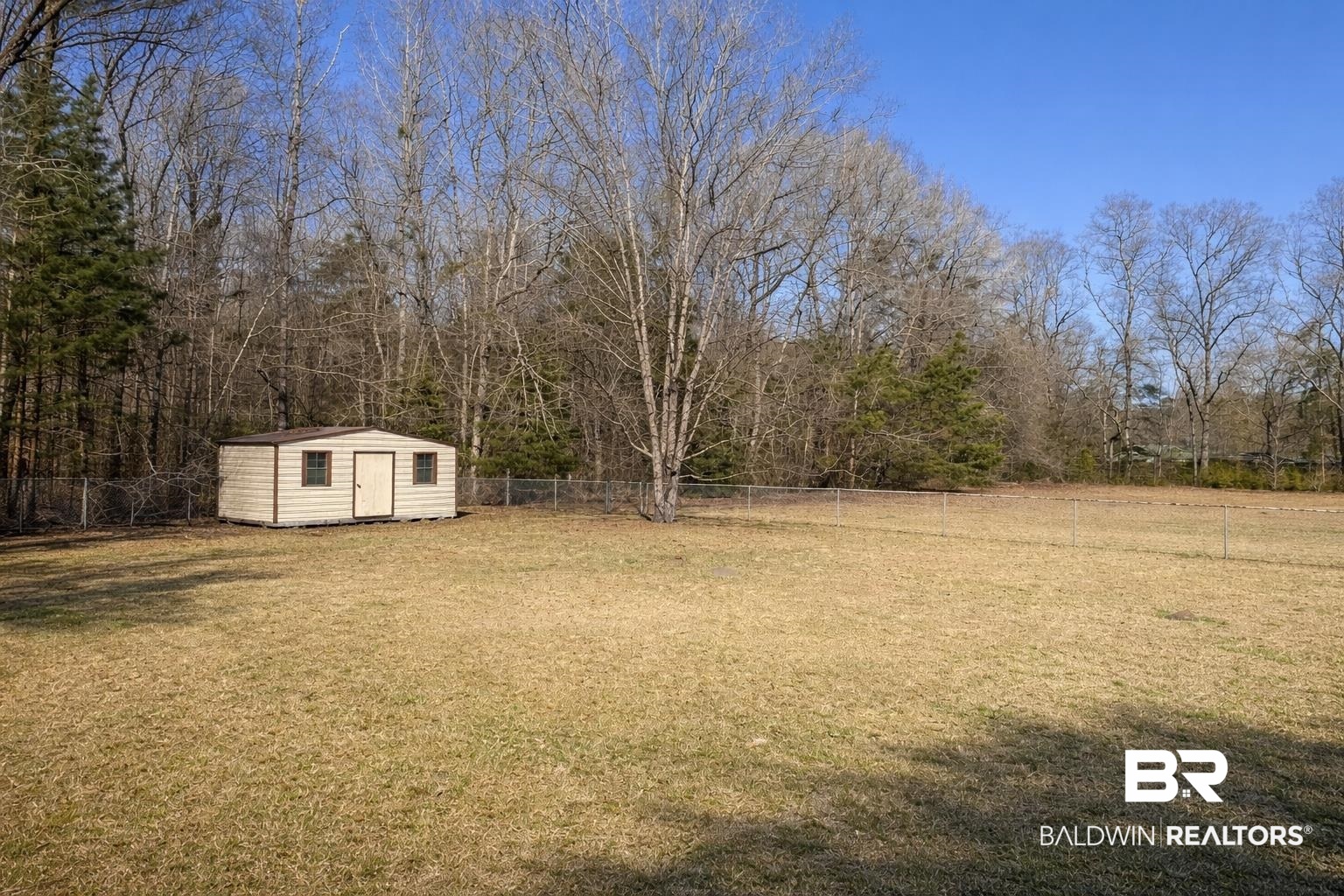 98 Evans Avenue Brewton, AL 36426 - Photo 16 of 18 Fenced backyard featuring a storage unit