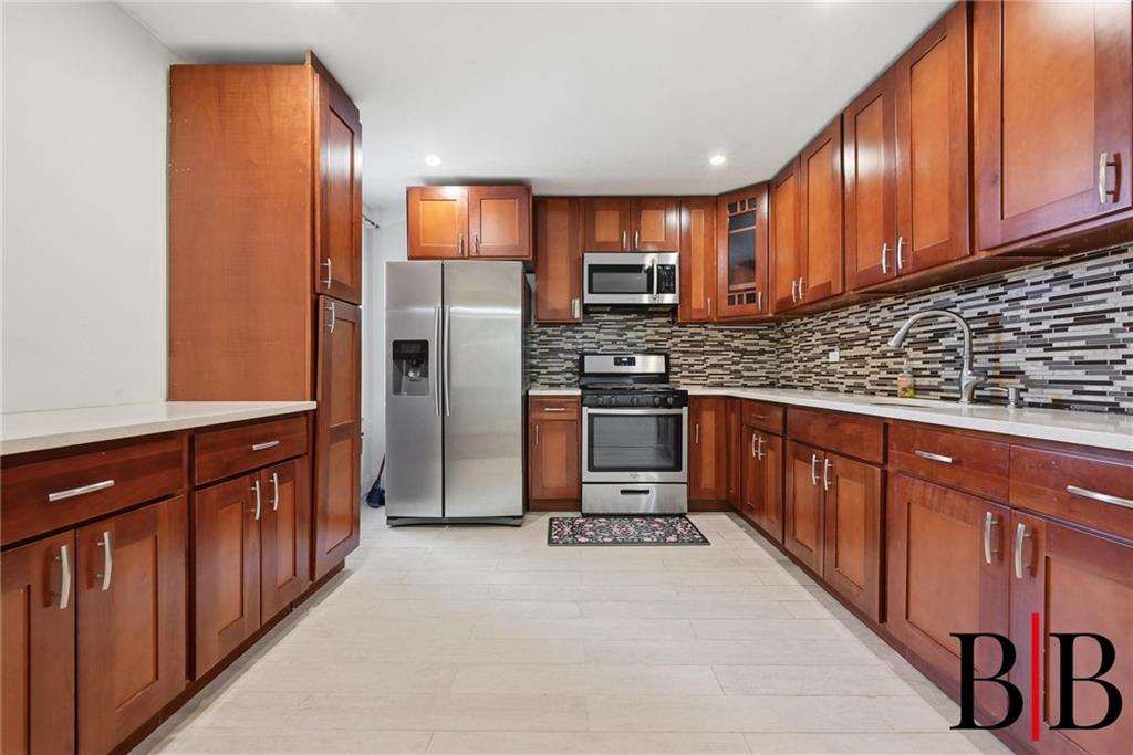 2270 Plumb 1 Street, Unit 2D Brooklyn, NY 11229 - Photo 4 of 13 a kitchen with stainless steel appliances granite countertop wooden cabinets a stove top oven a sink and dishwasher