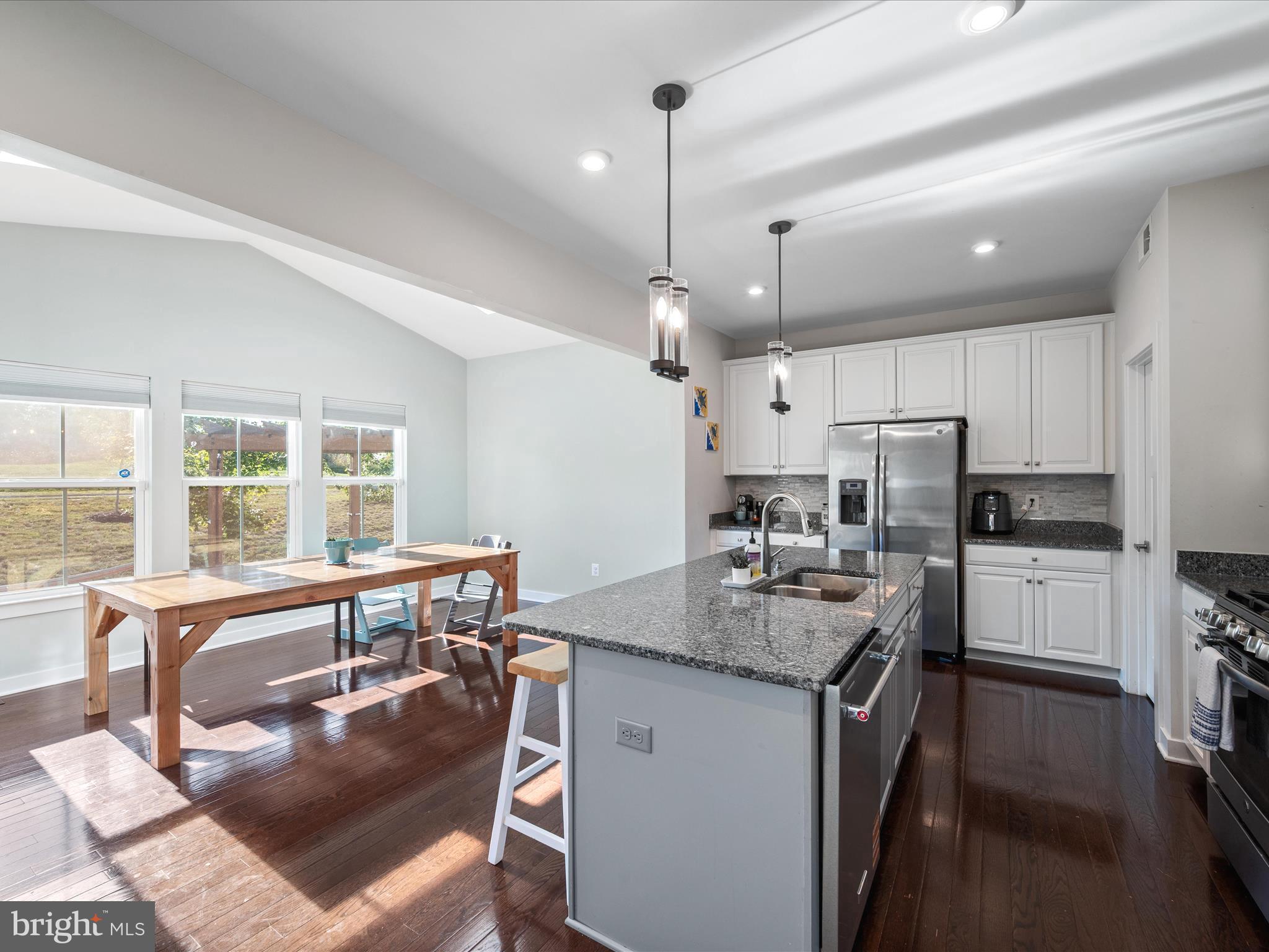 124 Emperor Drive White Post, VA 22663 - Photo 5 of 28 a kitchen with a refrigerator a stove a sink dishwasher with a dining table and chairs with wooden floor