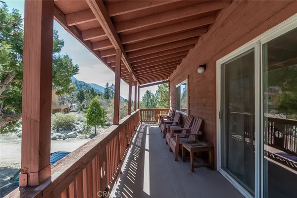 a view of a balcony with chairs and wooden fence