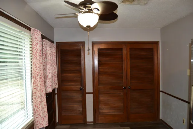 a view of a hallway with wooden floor and chandelier