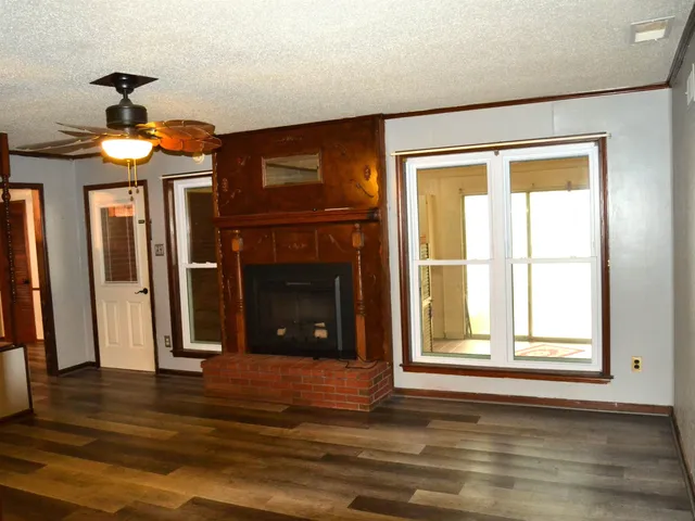 a view of a livingroom with a fireplace and window