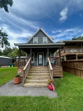 a view of a house with wooden deck and furniture