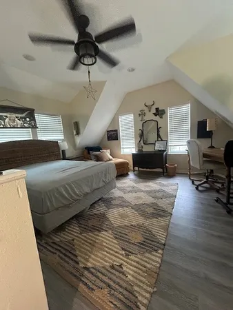 a spacious bedroom with a bed wooden floor and window