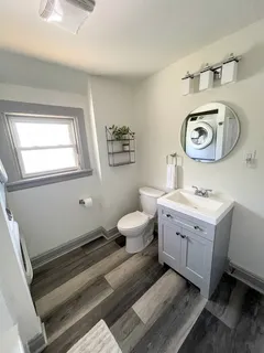 a spacious bathroom with a granite countertop toilet a sink and a mirror