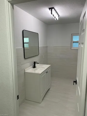 a bathroom with a sink a toilet and mirror