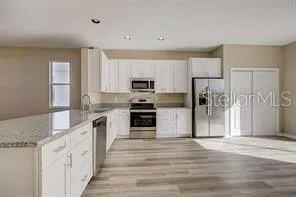 a large kitchen with cabinets stainless steel appliances and a counter space