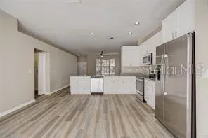 a large kitchen with kitchen island a large counter top space a sink stainless steel appliances and cabinets