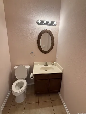 a bathroom with a toilet a sink and a mirror