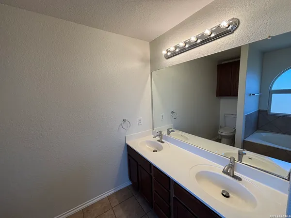 a bathroom with a double vanity sink and a mirror