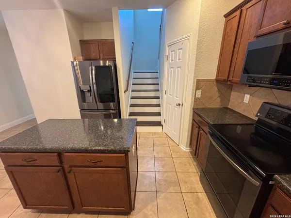 a kitchen with stainless steel appliances granite countertop a sink and a stove