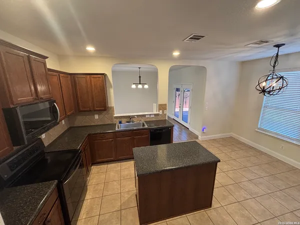 a kitchen with granite countertop a stove and a refrigerator