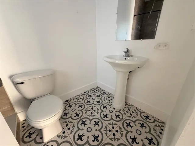 a bathroom with a sink toilet and a mirror