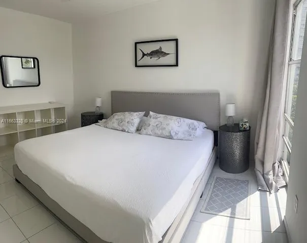 a large bed sitting in a bedroom next to a window