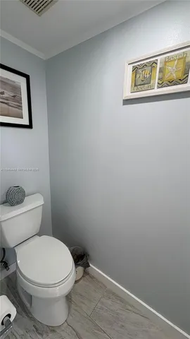 a white toilet sitting next to a white wall