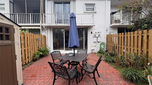 a view of a dinning table and chairs in patio of the house