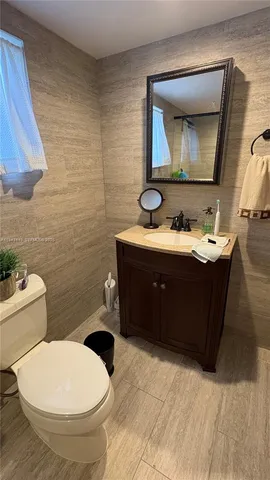 a bathroom with a toilet sink and mirror