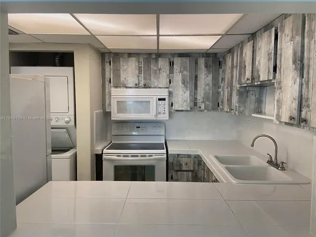 a kitchen with stainless steel appliances kitchen island a sink stove and refrigerator