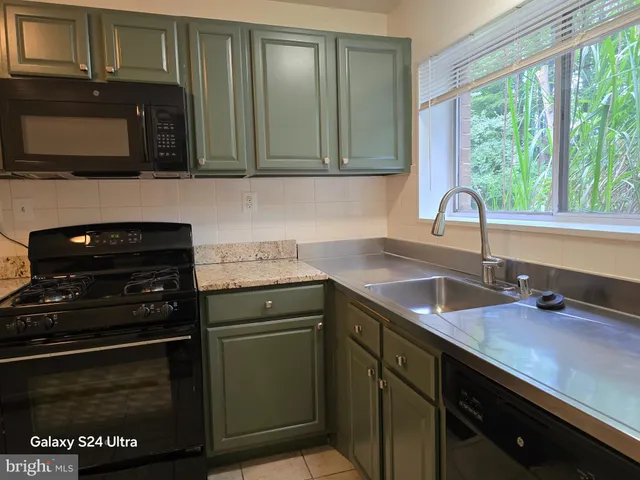 a kitchen with stainless steel appliances a stove sink and cabinets