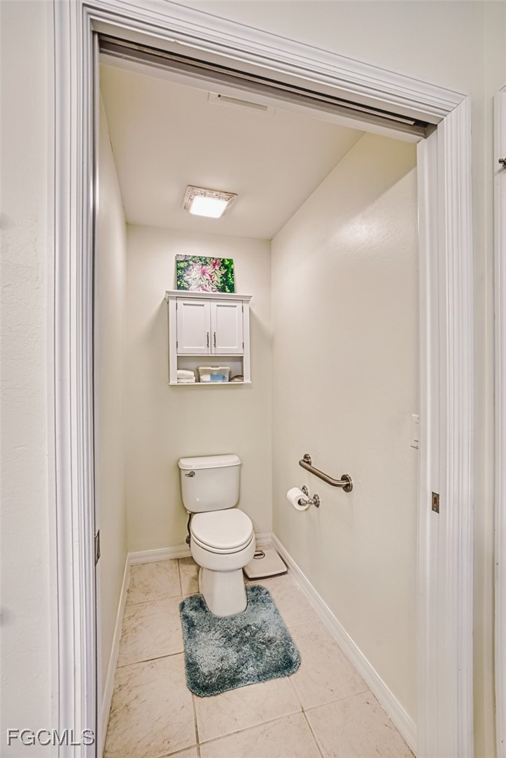 11611 Navarro Way, Unit 2002 Fort Myers, FL 33908 - Photo 22 of 45 a bathroom with a toilet a sink and a mirror