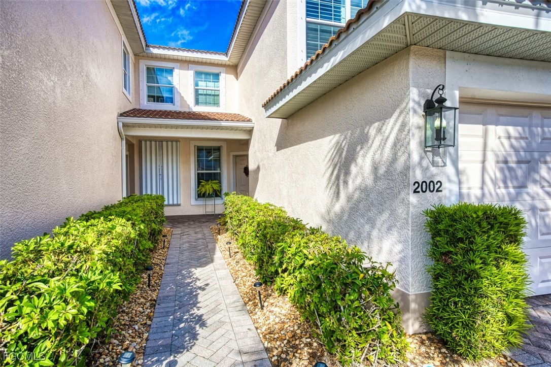 11611 Navarro Way, Unit 2002 Fort Myers, FL 33908 - Photo 35 of 45 a front view of a house with garden