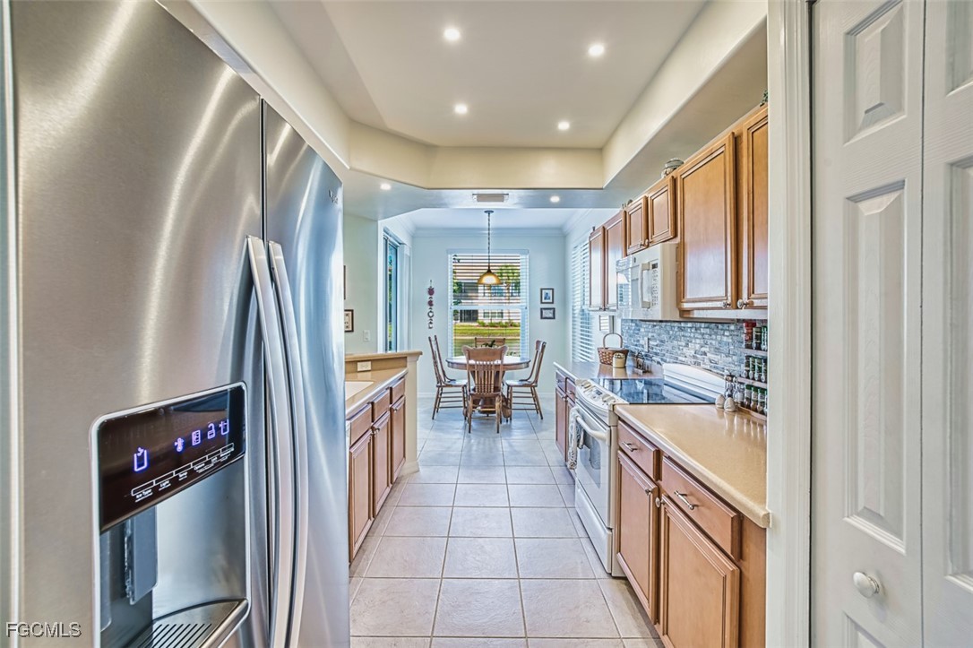 11611 Navarro Way, Unit 2002 Fort Myers, FL 33908 - Photo 10 of 45 a kitchen with stainless steel appliances granite countertop a refrigerator and a sink