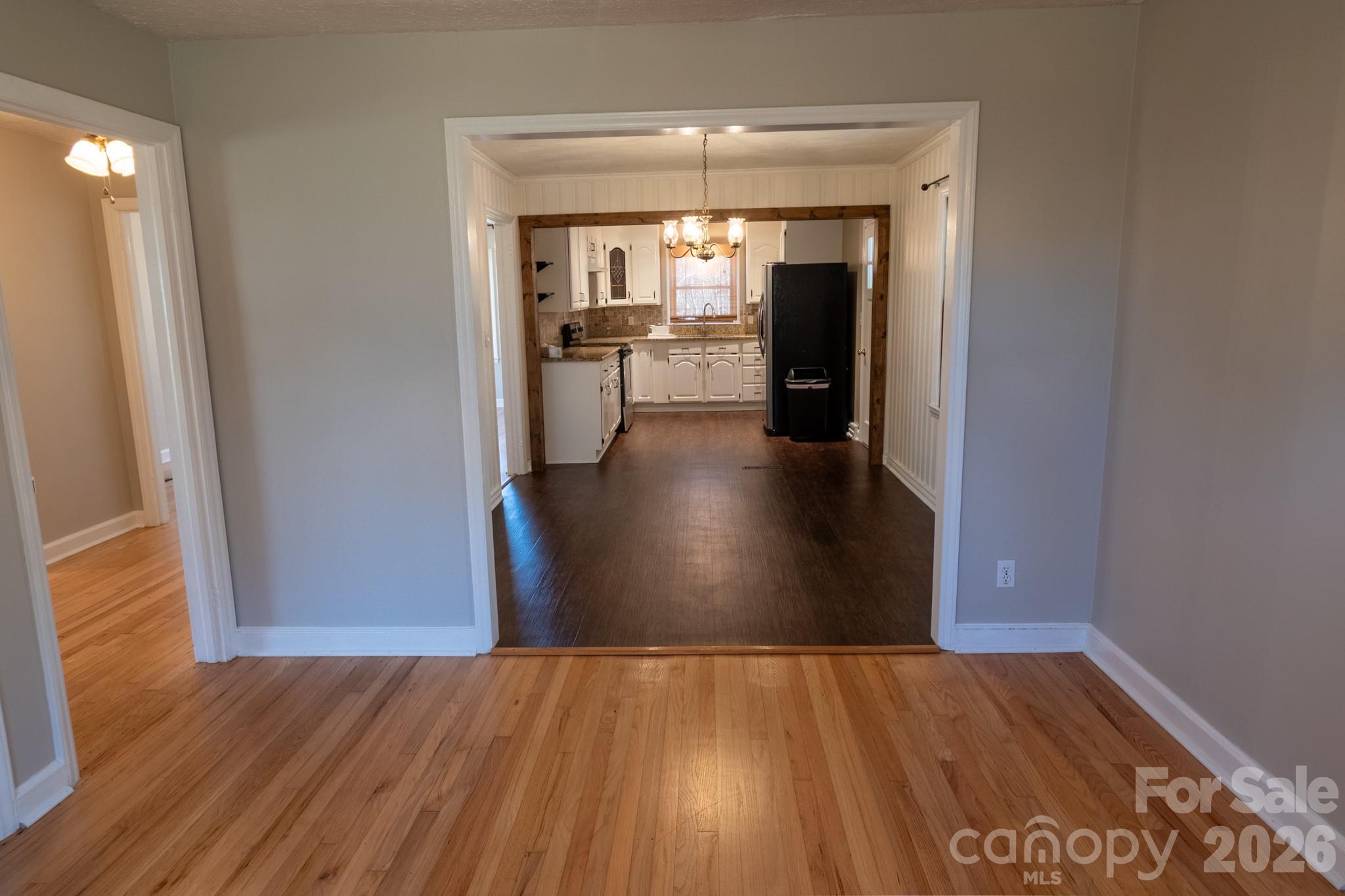 2113 Randolph Road Shelby, NC 28150 - Photo 17 of 39 wooden floor in an empty room and a kitchen