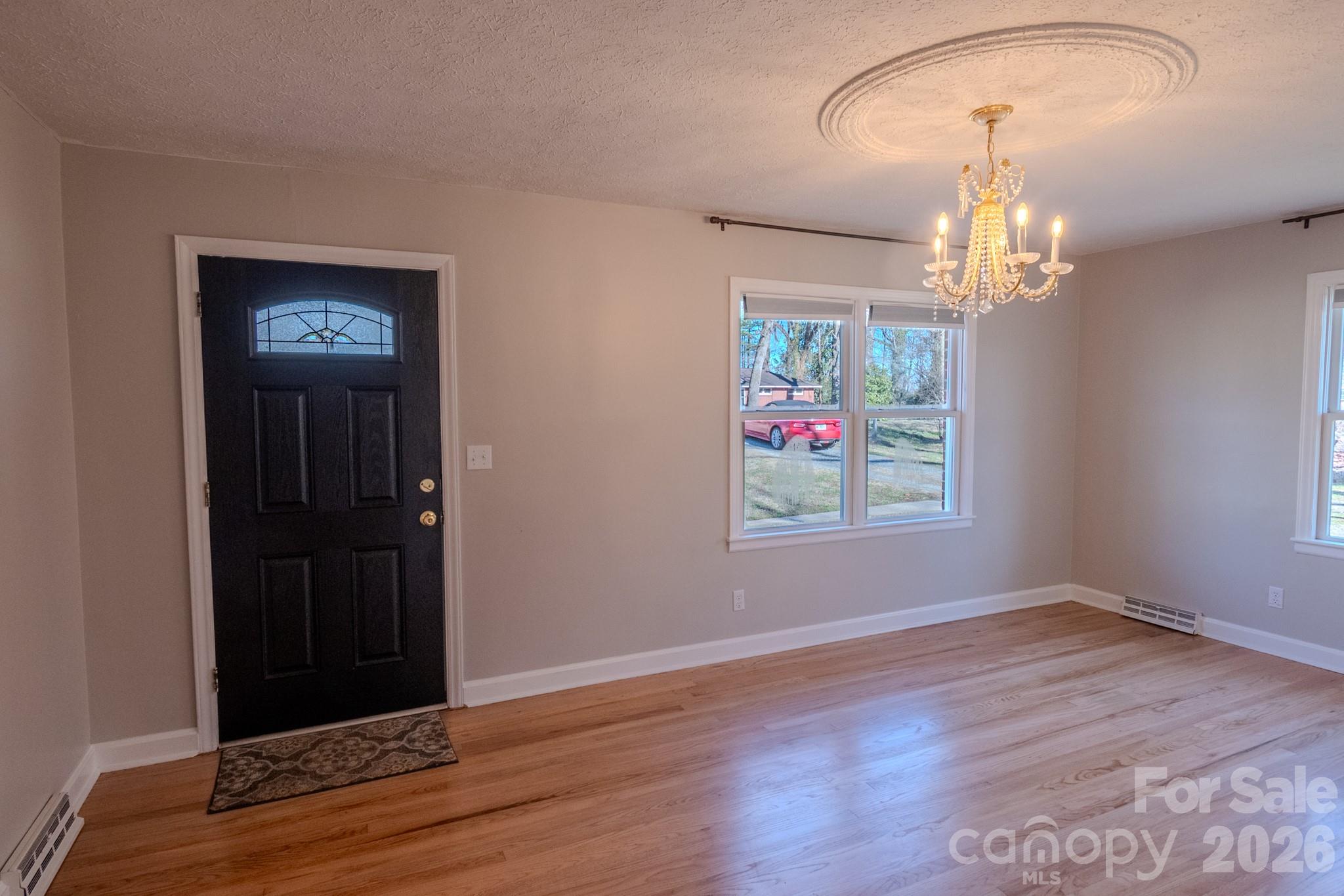 2113 Randolph Road Shelby, NC 28150 - Photo 3 of 39 an empty room with wooden floor chandelier and windows