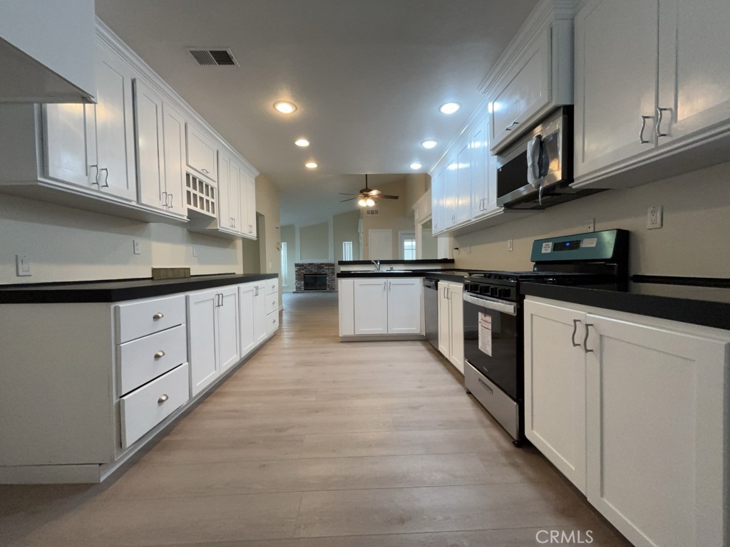 9263 Owari Lane Riverside, CA 92508 - Photo 5 of 17 a kitchen with granite countertop white cabinets and stainless steel appliances