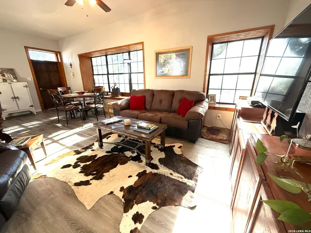 a living room with furniture a flat screen tv and a window