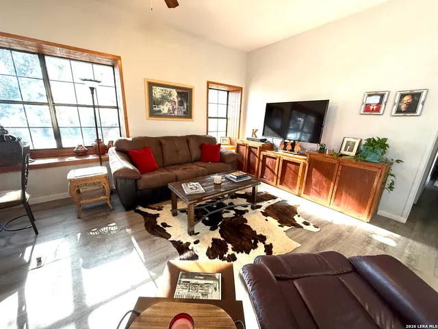 a living room with furniture kitchen view and a flat screen tv