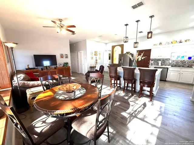 a living room with furniture kitchen view and a flat screen tv